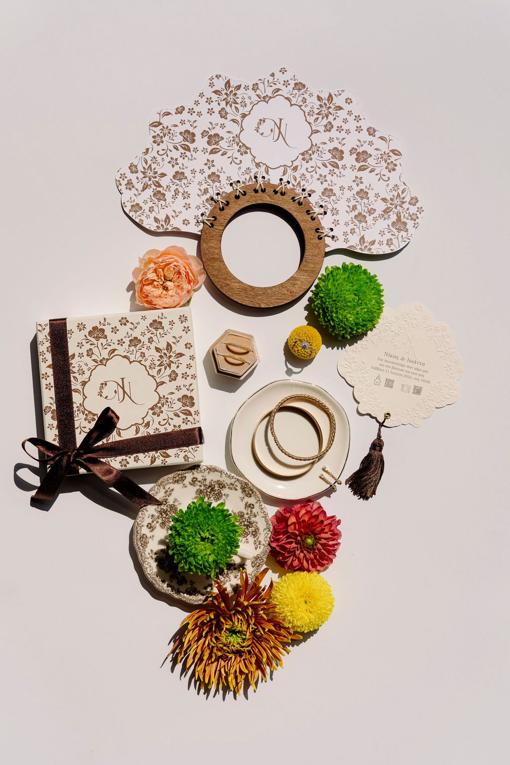 Flat lay of Mount Olympus wedding details with floral stationery, gold jewelry, wedding rings and colorful flowers in Greece.