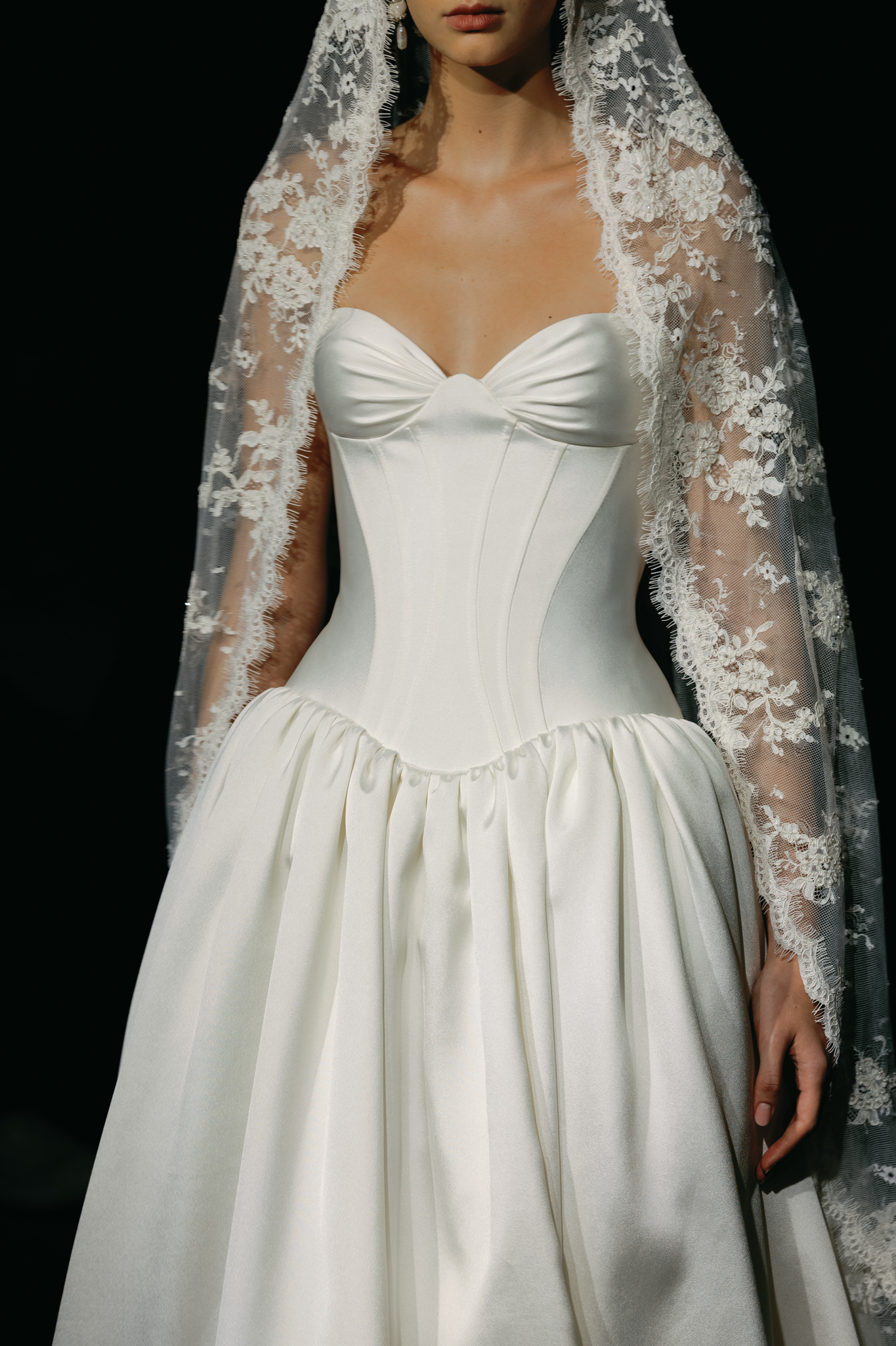 Ivory corset wedding gown featuring a sweetheart neckline, sheer lace sleeves and full gathered skirt