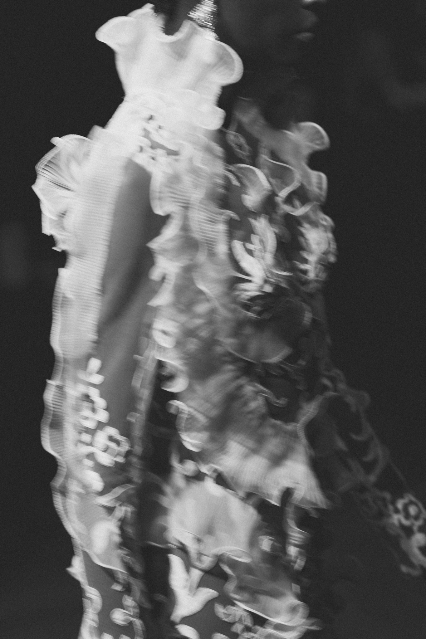 Black-and-white close-up of dimensional floral appliqués decorating an elaborate bridal couture design