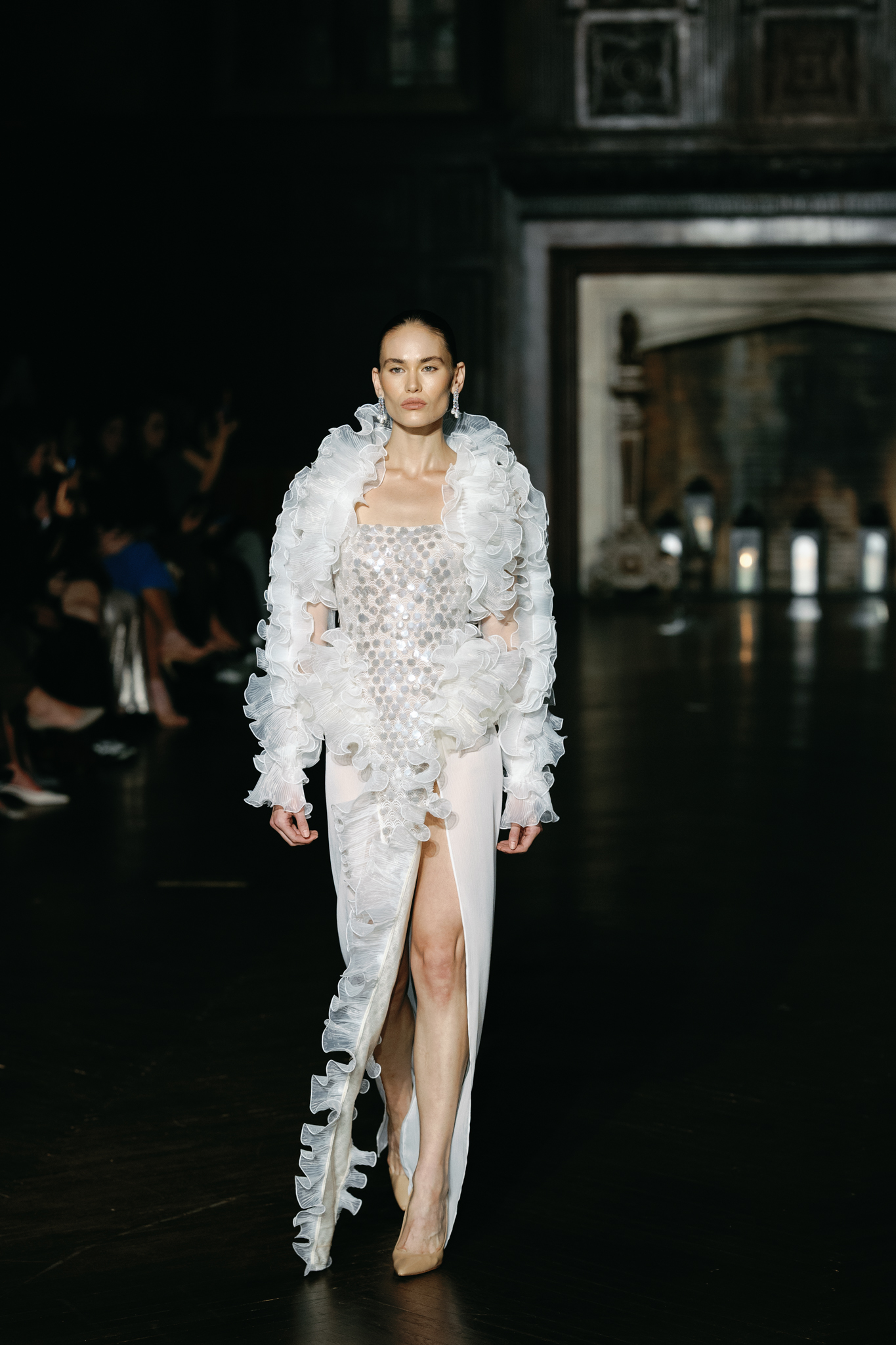 Model walking the NYBFW runway in a white embellished bridal look with voluminous textured detailing